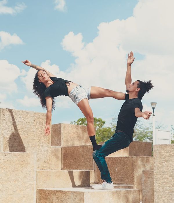 Woman performing a balanced yoga pose in a dark room.